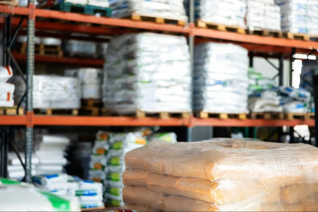 Diferentes tipos de insumos agrícolas em loja, empilhados em diferentes estantes.