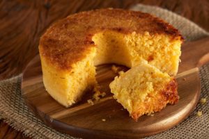 Bolo de fubá cortado sobre tábua de madeira