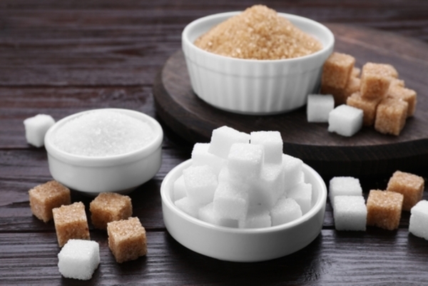 Xilitol ou stévia: qual adoçante escolher? Tire todas as suas dúvidas 1 Diversos tipos de açúcar dispostos sobre uma mesa de madeira, incluindo açúcar refinado, cristal, mascavo e demerara, apresentados em colheres e tigelas de cerâmica.