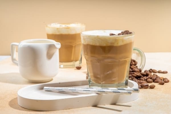 Café cremoso com leite em pó: confira 3 receitas deliciosas 2 Bebida gelada de café cremoso com leite, servida em copo transparente e decorada com chantilly.