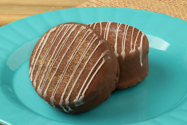 Pão de mel tradicional servido em um prato azul, com foco seletivo destacando a textura do doce e detalhes do prato. 