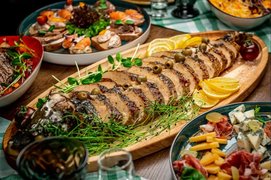 Peixe para Páscoa inteiro assado e fatiado em uma tábua de madeira com guarnições.