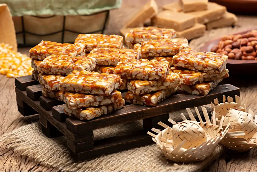 Mesa repleta de doces típicos da festa junina, com destaque para o pé-de-moloque.