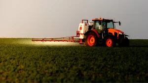 Trator fazendo a pulverização da lavoura com fertilizante foliar, um tipo de fertilizante especial.